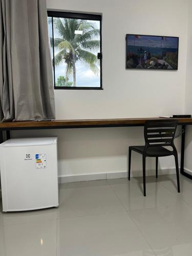 リオブランコにあるCubo Hotelのテーブルと椅子、窓が備わる客室です。