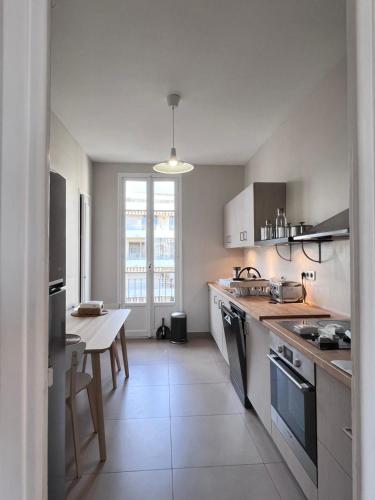 une cuisine blanche avec une table et une table dans l'établissement 4 chambres. Nice French Riviera, à Nice