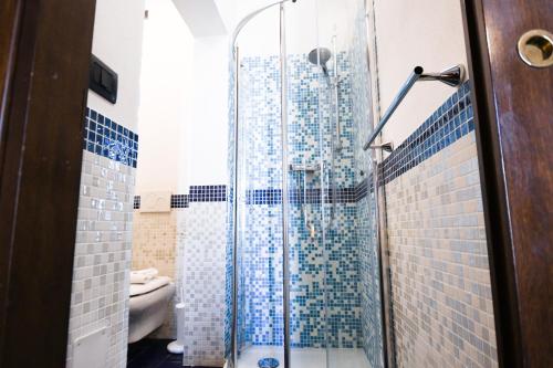 a bathroom with a shower with blue tiles at Bienestar - Maison de Charme in Alghero