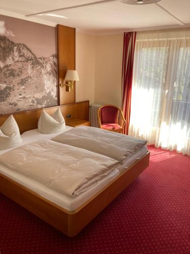 a bedroom with a large bed in a room at Alpenhof in Bayrischzell