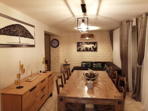 una sala da pranzo con tavolo e sedie in legno di Médina maison 4 chambres 100m2 a Beuvrages