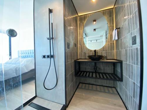 La salle de bains est pourvue d'une douche, d'un lavabo et d'un miroir. dans l'établissement Moderno Depto Estudio frente a Playa Amarilla, à Concón