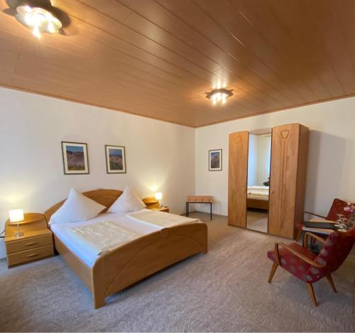 a bedroom with a large bed and a chair at Hotel Hieronimi in Cochem