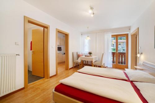 a bedroom with two beds and a dining room at Fröhlichhof Wohnung Pink Lady in Lagundo