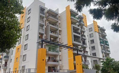 an apartment building with yellow and white at ADI HOSPITALITY AND TOURS PRIVATE LIMITED in Bangalore