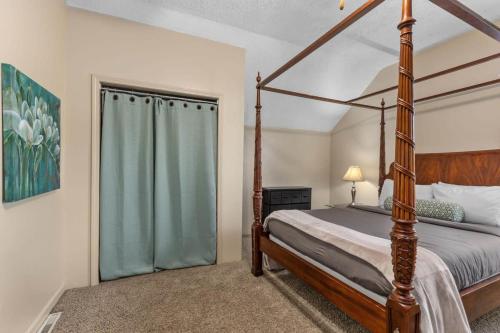 a bedroom with a four poster bed and a window at Charming 4BR Westside Home in Beer City USA in Grand Rapids