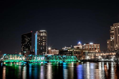 a bridge over a river in a city at night at Charming 4BR Westside Home in Beer City USA in Grand Rapids
