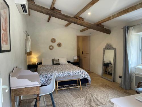 a bedroom with a bed and a table and a mirror at Lou Mas in Gordes