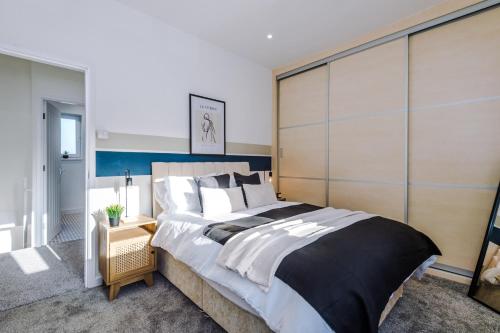 a bedroom with a large bed with a large headboard at Spacious 2-Bedroom House near Wakefield Centre and Train Station with Free Parking, Ideal for Contractors & Long Stays - NordStay in Wakefield
