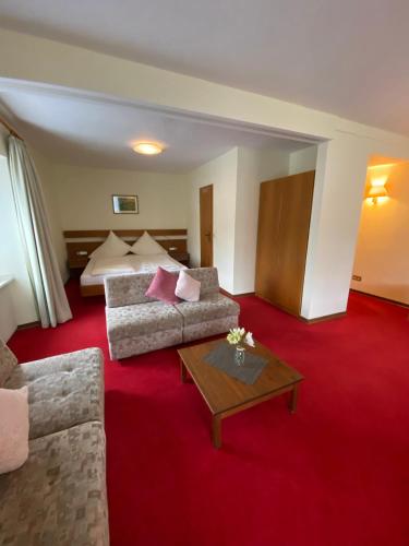 a hotel room with a couch and a bed at Hotel Hieronimi in Cochem