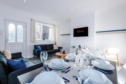 a living room with a table with wine glasses at Spacious 2-Bedroom House near Wakefield Centre and Train Station with Free Parking, Ideal for Contractors & Long Stays - NordStay in Wakefield