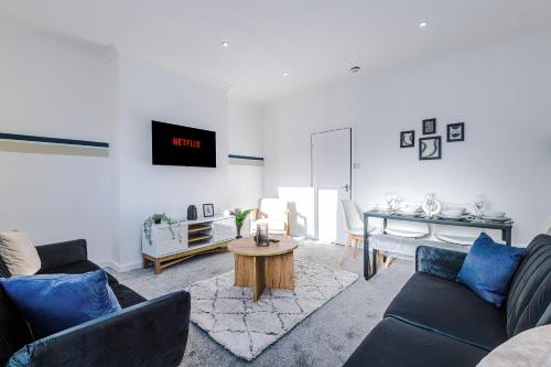 a living room with a couch and a table at Spacious 2-Bedroom House near Wakefield Centre and Train Station with Free Parking, Ideal for Contractors & Long Stays - NordStay in Wakefield