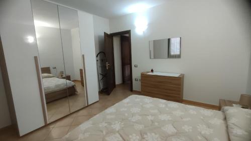 a bedroom with a mirror and a bed and a sink at Sara Sole & Mare in Torpè