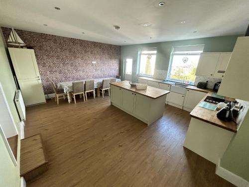 a kitchen with white cabinets and a dining room at Sandy Lodge in Hornsea