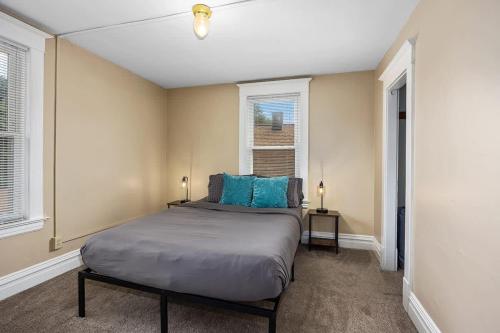 Un dormitorio con una cama con almohadas azules. en Charming 4BR Westside Home in Beer City USA en Grand Rapids