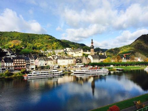 eine Stadt auf einem Fluss mit Booten im Wasser in der Unterkunft Hotel Hieronimi in Cochem