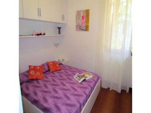 een slaapkamer met een paars bed met 2 kussens bij Charming apartment with garden - Beahost in Bibione