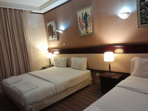 a hotel room with two beds and two lamps at Arfalon Hotel and Tourism in Makkah