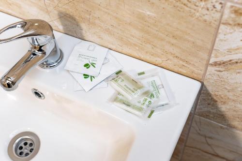 a bathroom sink with toothbrushes and toothpaste at Hotel Taurus in Ostrava