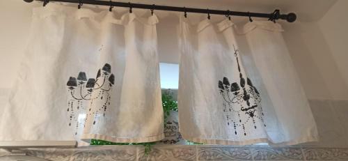two white curtains with a picture of a cat on a window at LINO'S HOUSE in Sori