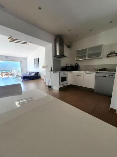 une grande cuisine blanche avec vue sur l'océan dans l'établissement Appartement face à la mer 4 pers, à Propriano