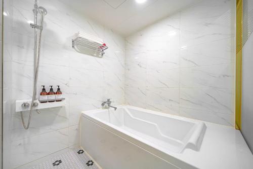 uma casa de banho branca com uma banheira e um lavatório em Number 25 Gyeongju City Hall em Gyeongju