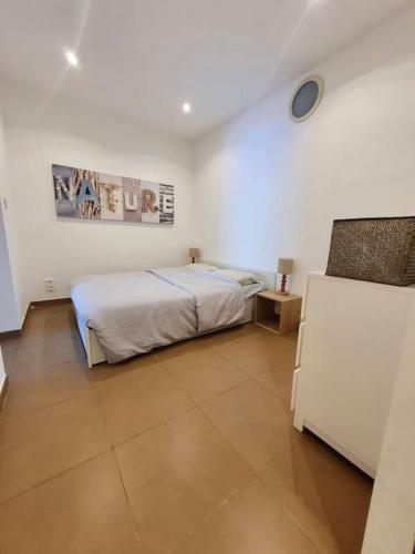 une chambre avec un lit dans une pièce blanche dans l'établissement Appartement face à la mer 4 pers, à Propriano