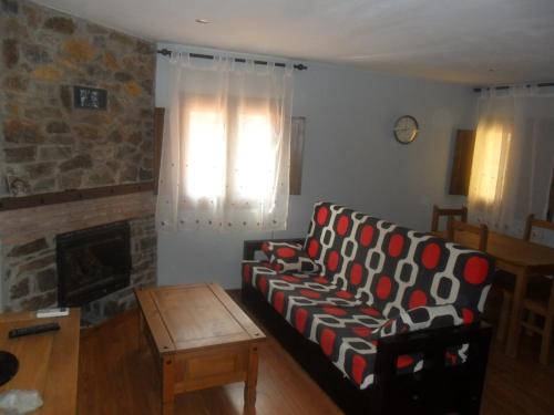 - un salon avec un canapé et une cheminée dans l'établissement La Jelechera, à El Gasco