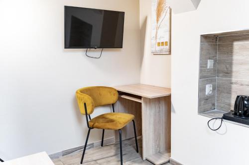 a room with a desk with a chair and a tv at Hotel Taurus in Ostrava