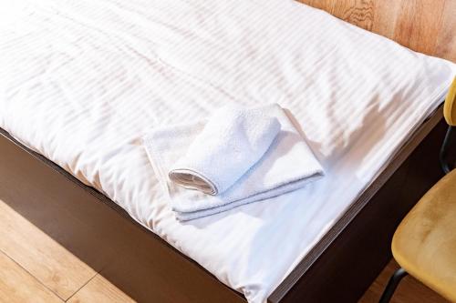 a white towel sitting on top of a bed at Hotel Taurus in Ostrava