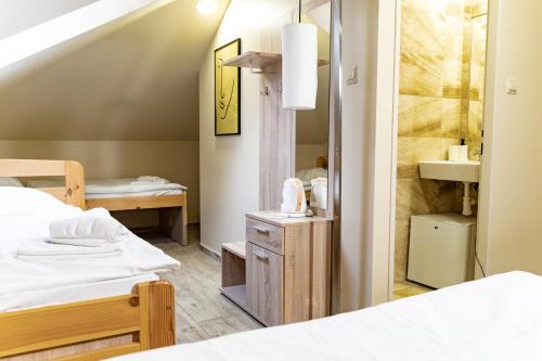 mały pokój z 2 łóżkami i lustrem w obiekcie Hotel Taurus w Ostravie