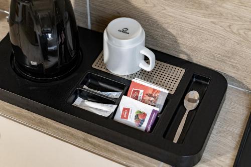 a coffee maker with a cup on a counter at Hotel Taurus in Ostrava