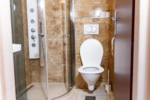 a bathroom with a toilet with a glass shower stall at Hotel Taurus in Ostrava