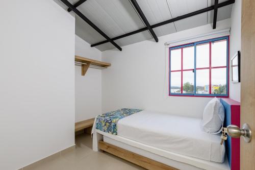 a bedroom with a bed and a window at Full Apartamento Privado 202 Guatapé in Guatapé