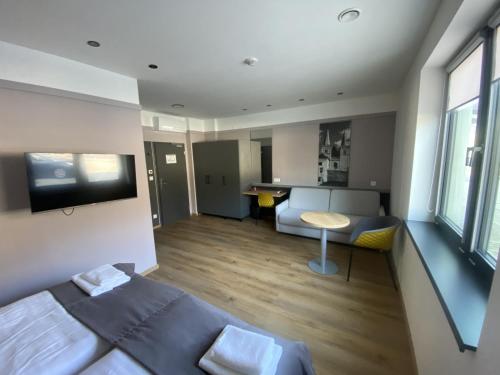 a bedroom with a bed and a kitchen with a table at TANKER Apartments & Bistro Čaradice in Čaradice