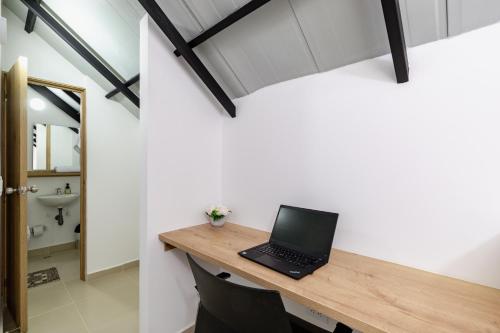 a laptop computer sitting on a wooden desk in a room at Full Apartamento Privado 202 Guatapé in Guatapé