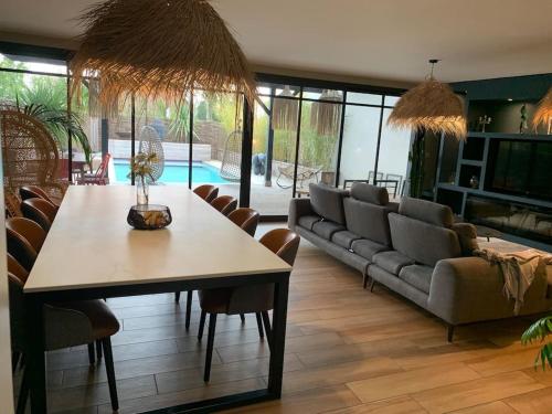 un salon avec une table et un canapé dans l'établissement Villa Le Patio Bleu au calme, piscine chauffée, centre ville, à Arès