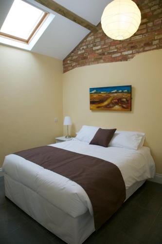 1 dormitorio con 1 cama grande en una habitación en Owls Hoot at Tove Valley Cottages, en Towcester