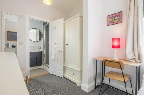 ein Schlafzimmer mit einem Schreibtisch und einem Bett sowie ein Badezimmer in der Unterkunft Central 4 Bed Home With Parking in Cambridge