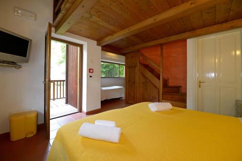 um quarto com uma cama amarela com duas toalhas em Il Mulino Di Mattie em Bussoleno