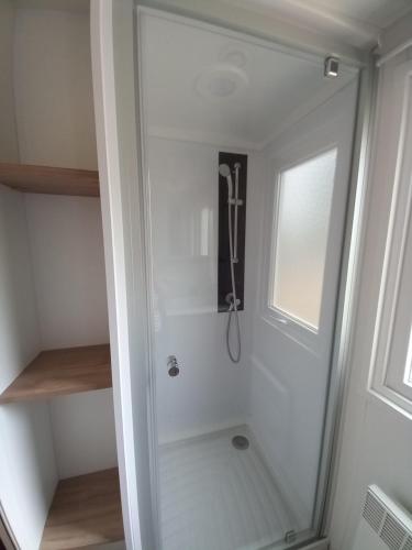 a shower with a glass door in a bathroom at mobilhome 6/8 personnes in La Tremblade