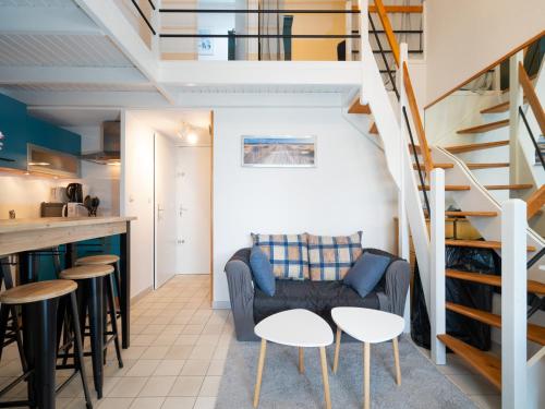 - un salon avec un canapé, des tables et un escalier dans l'établissement AQUAPLAGE - B117 - Superbe duplex 6 pers, au Cap d'Agde