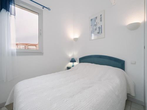 une chambre blanche avec un lit et une fenêtre dans l'établissement AQUAPLAGE - B117 - Superbe duplex 6 pers, au Cap d'Agde
