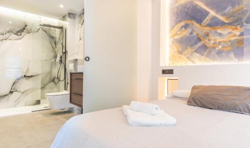 a bedroom with a white bed and a painting on the wall at Apartamento para dos al lado de la Alhambra, en pleno centro in Granada