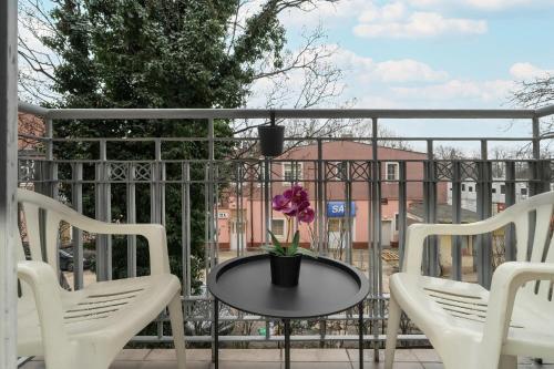 a table with a flower on a balcony at Cosy Studio in the Centre of Poznań with Balcony by Renters in Poznań