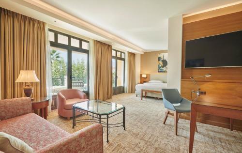 um quarto de hotel com um sofá e uma televisão em Hyatt Regency Thessaloniki em Tessalônica
