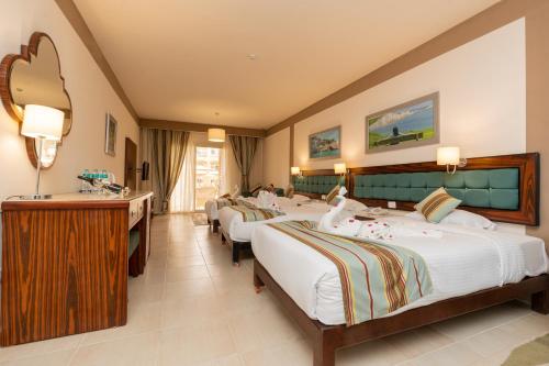 a hotel room with four beds and a sink at El Karma Beach Resort & Aqua Park - Hurghada in Hurghada