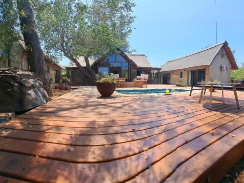 a wooden deck with a pool in a backyard at La Dolce Vita in Hoedspruit