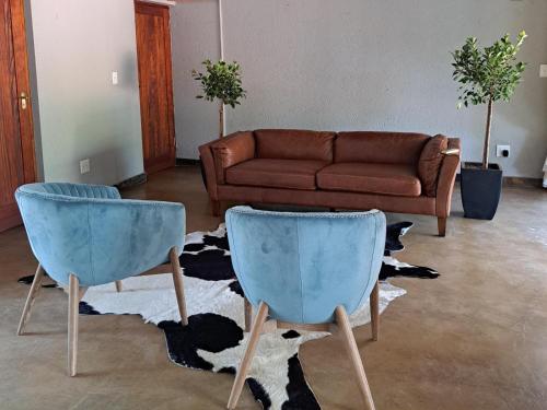 two blue chairs in a living room with a couch at La Dolce Vita in Hoedspruit