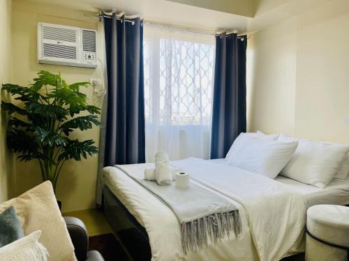 um quarto com uma cama e uma janela com cortinas azuis em City Hub Studio Unit with FAST Wifi, Netflix at Aspira Tower 1 em Cagayan de Oro